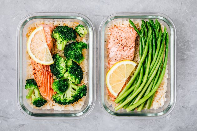 Stay healthy on a budget: Meal prep lunch box containers with baked salmon fish, rice, green broccoli and asparagus