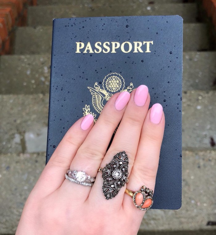 How to travel with jewelry! Image shows my hand with my antique wedding set and two other antique rings, holding a US passport.